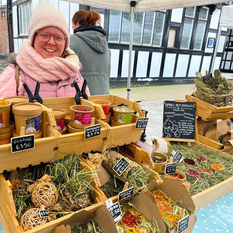 Small pet supplies market stall with guinea pig forages treats and toys.